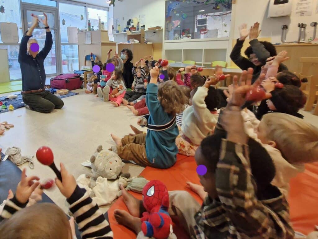Enfants de la crèche des Montchatons participant activement à la séance musicale avec des maracas