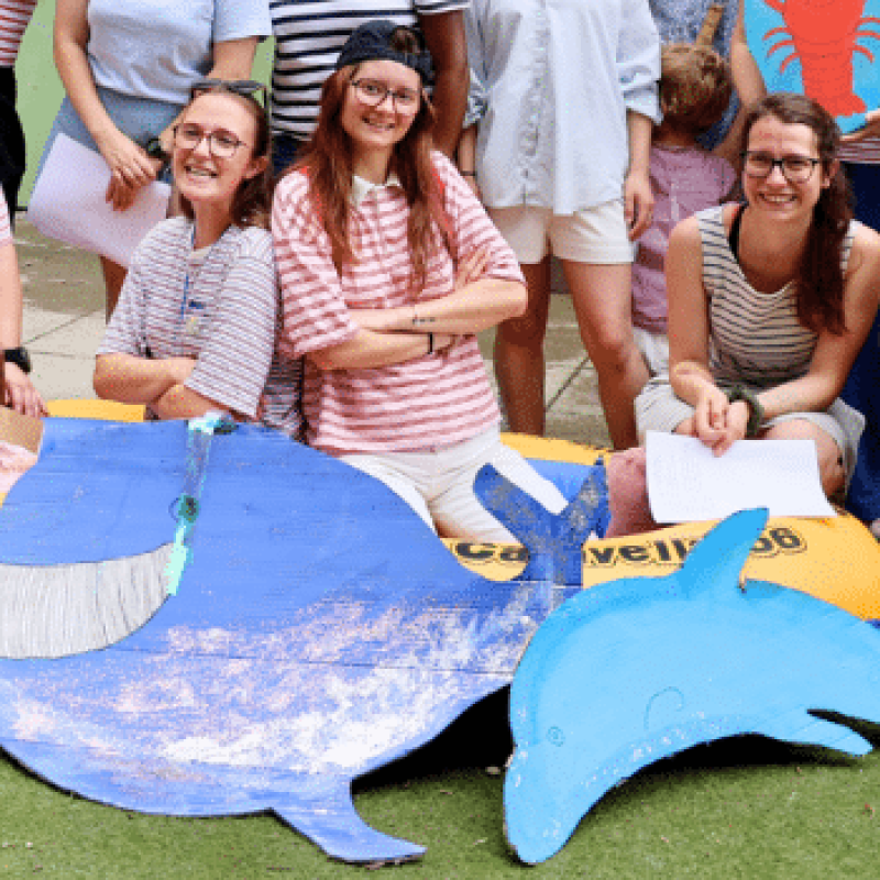Bannière de la fête d'été de la crèche Montchat Bada à Lyon 3 : trois professionnelles derrière une baleine et un dauphin en carton peint