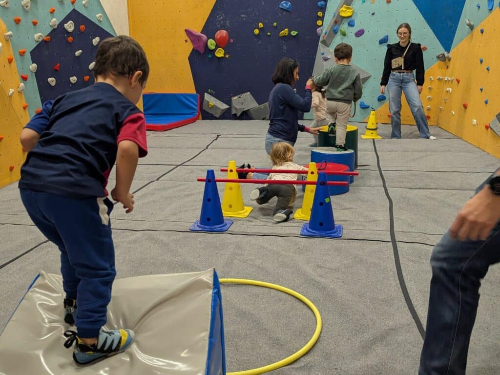 Enfants réalisant un parcours psychomoteur dans une salle d'escalade